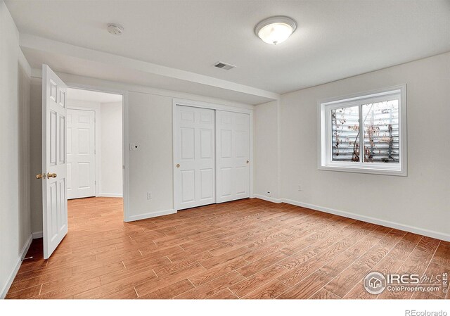 unfurnished bedroom with light hardwood / wood-style floors and a closet