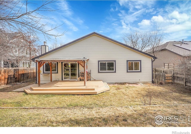 rear view of house with a yard and a deck