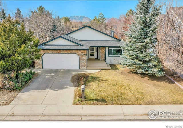 single story home featuring a garage, a mountain view, and a front lawn