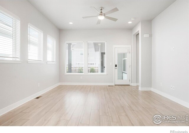 unfurnished room with baseboards, light wood finished floors, visible vents, and a ceiling fan