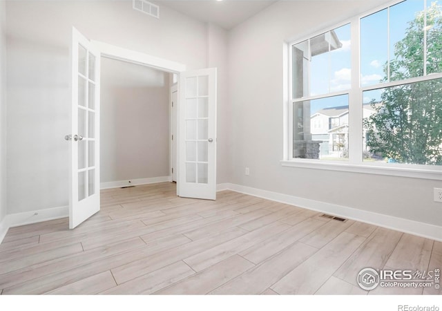 spare room with french doors, visible vents, and light wood-style floors