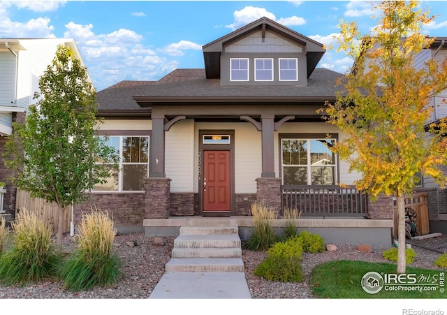 craftsman-style home featuring a porch and stone siding