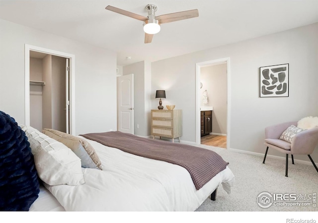 bedroom featuring a walk in closet, ceiling fan, light carpet, ensuite bath, and a closet