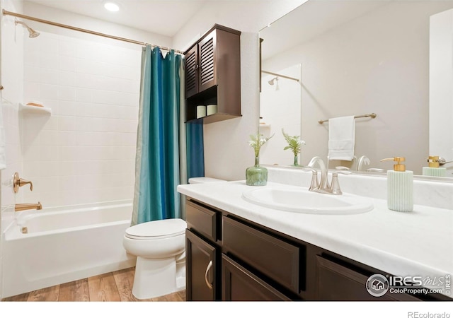 full bathroom with hardwood / wood-style flooring, vanity, shower / bath combination with curtain, and toilet