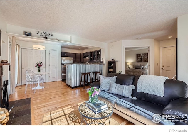 living room with light hardwood / wood-style flooring and a textured ceiling