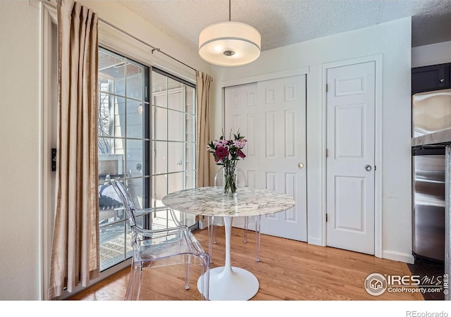 dining room with hardwood / wood-style floors and a textured ceiling