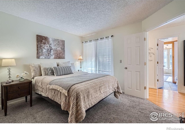 bedroom with carpet and a textured ceiling