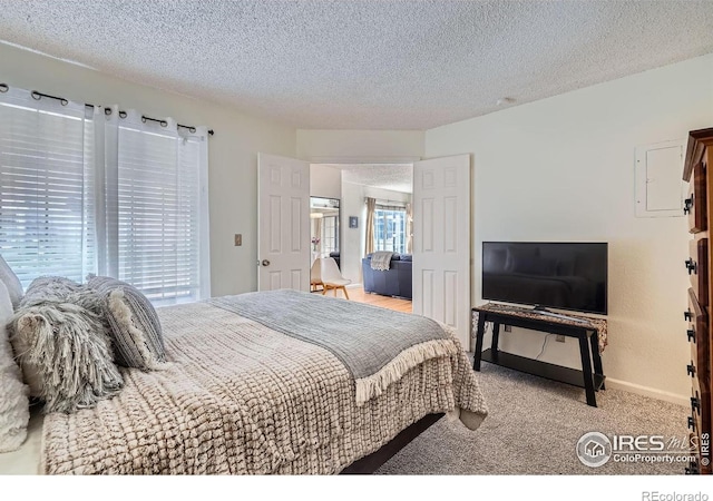 bedroom featuring light colored carpet and a textured ceiling