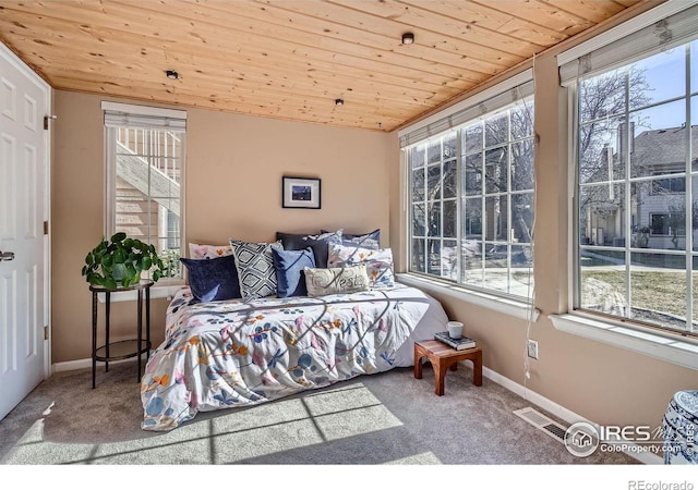 bedroom featuring wood ceiling, carpet flooring, and multiple windows