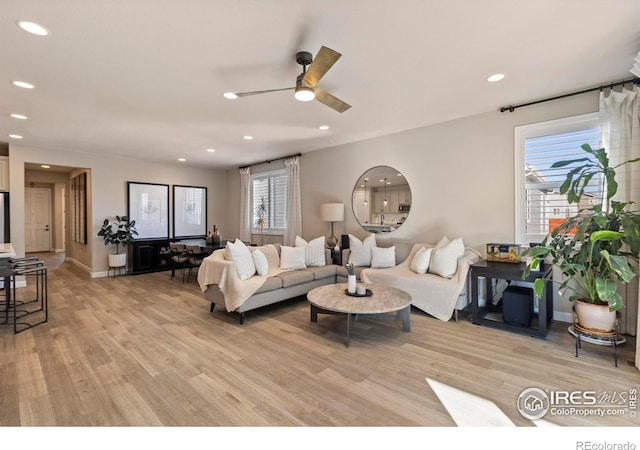 living room with ceiling fan and light hardwood / wood-style floors