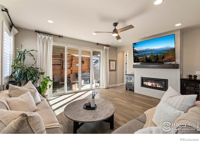 living room with ceiling fan, a healthy amount of sunlight, and light hardwood / wood-style flooring