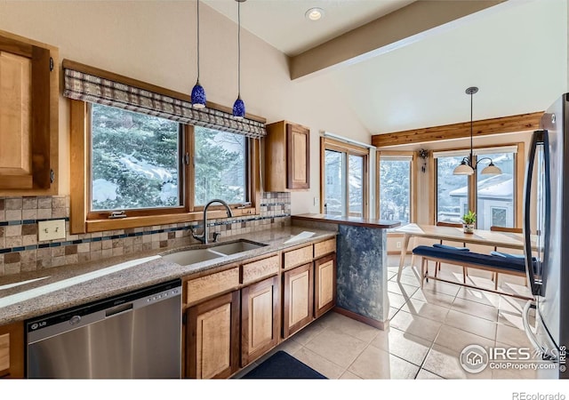 kitchen with pendant lighting, sink, light tile patterned floors, backsplash, and stainless steel appliances