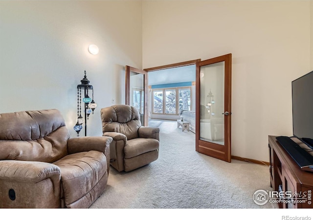 carpeted living room with a high ceiling