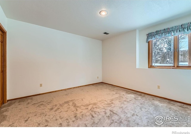 empty room with a textured ceiling and carpet