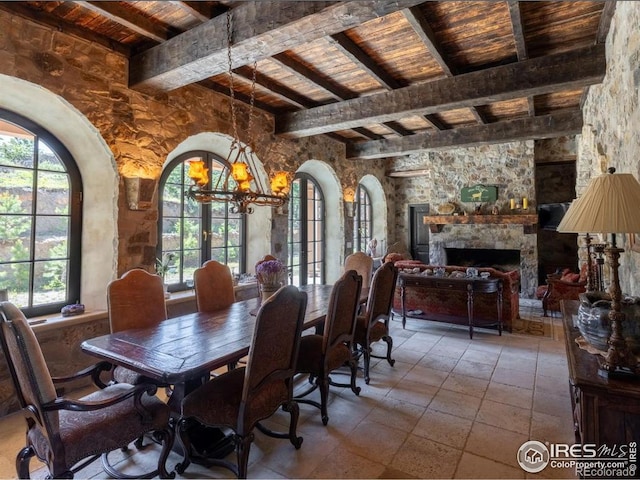 9200 Old Flowers Rd, Bellvue, CO 80512 - dining space featuring wood ceiling, healthy amount of natural light, beamed ceiling, a chandelier, and a stone fireplace