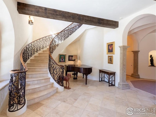 9200 Old Flowers Rd, Bellvue, CO 80512 - stairway featuring ornate columns, arched walkways, and beamed ceiling