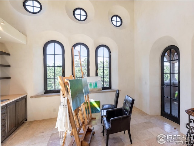 9200 Old Flowers Rd, Bellvue, CO 80512 - dining area featuring healthy amount of natural light, stone tile floors, arched walkways, and a towering ceiling