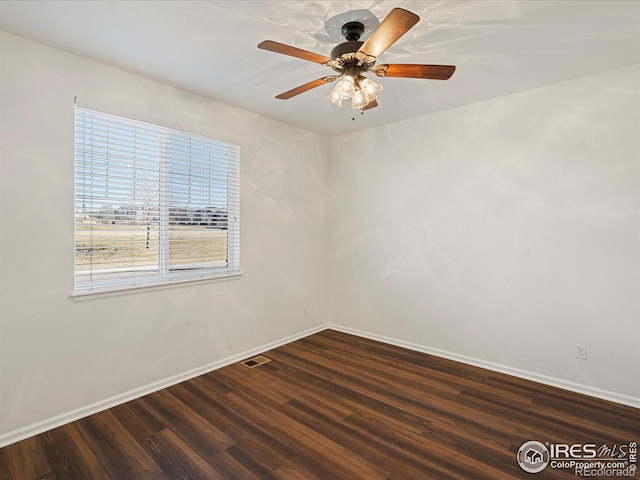 empty room featuring dark hardwood / wood-style flooring and ceiling fan