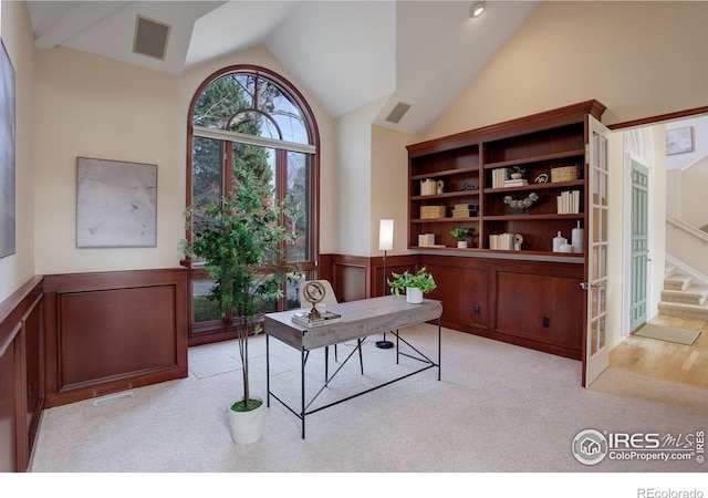 carpeted office featuring lofted ceiling