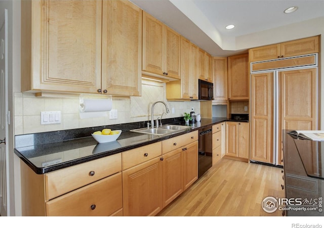 kitchen featuring sink, tasteful backsplash, black appliances, light brown cabinetry, and light wood-type flooring