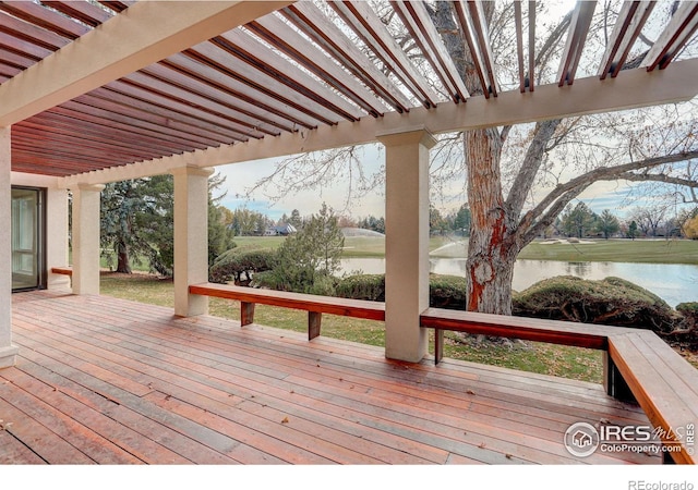 wooden terrace featuring a water view and a pergola