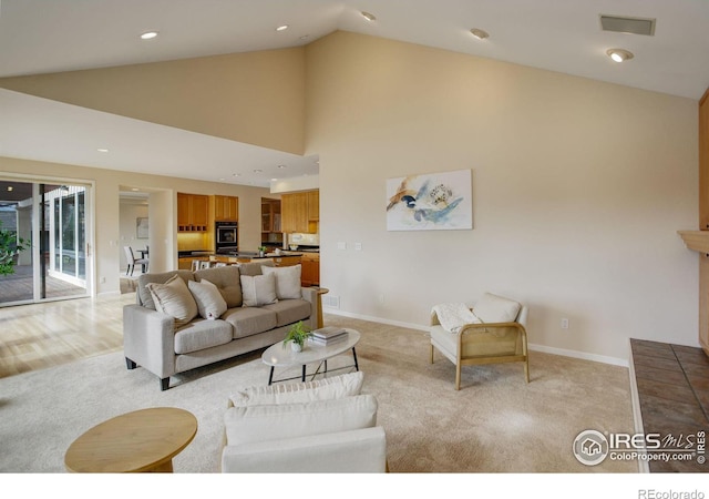 carpeted living room with high vaulted ceiling