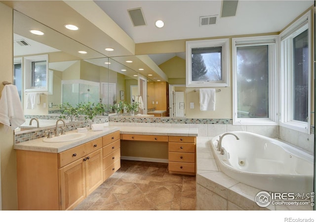 bathroom featuring lofted ceiling, vanity, a relaxing tiled tub, tasteful backsplash, and toilet