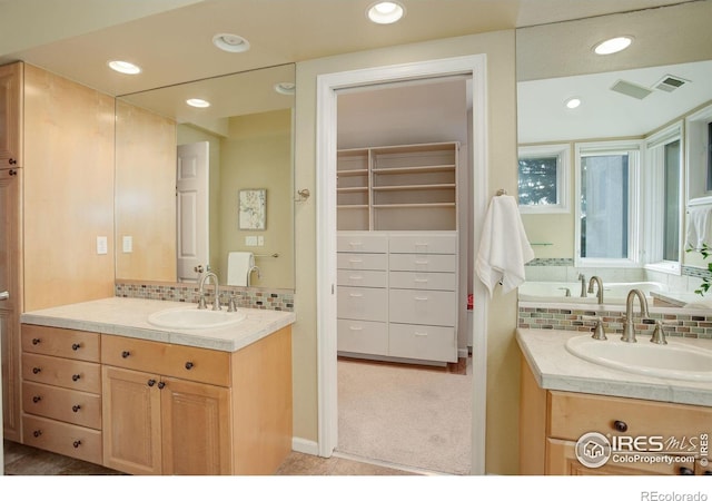 bathroom featuring vanity and backsplash