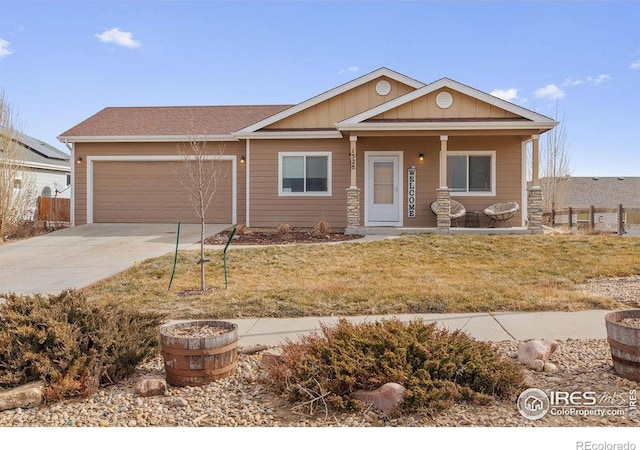 single story home with a garage, a front yard, and covered porch