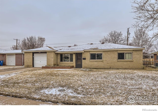 single story home featuring brick siding, an attached garage, roof with shingles, and fence