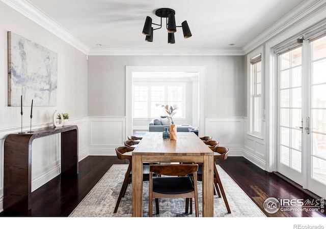 dining room with dark hardwood / wood-style flooring, crown molding, and a chandelier