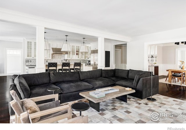 living room featuring ornamental molding, sink, and light hardwood / wood-style flooring