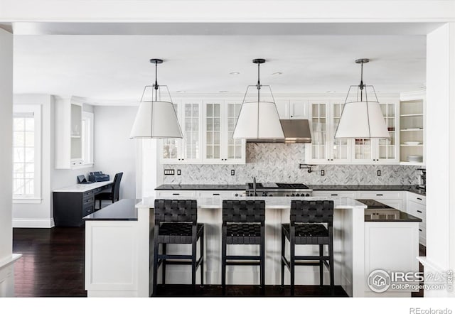 kitchen featuring white cabinetry, a kitchen bar, and decorative light fixtures