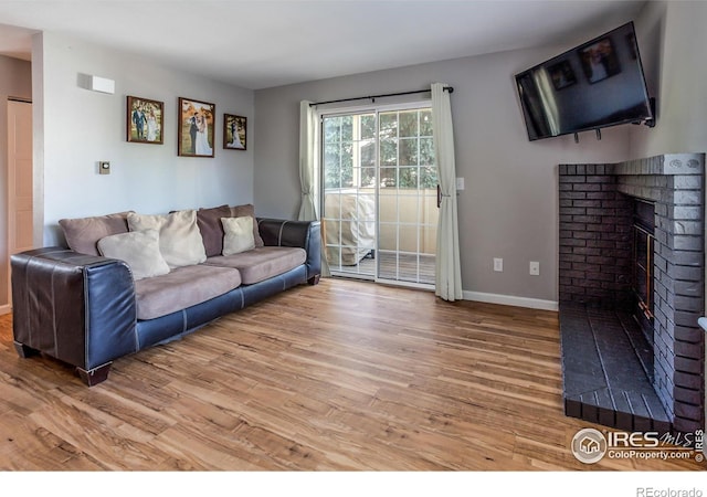 living room with hardwood / wood-style flooring and a brick fireplace