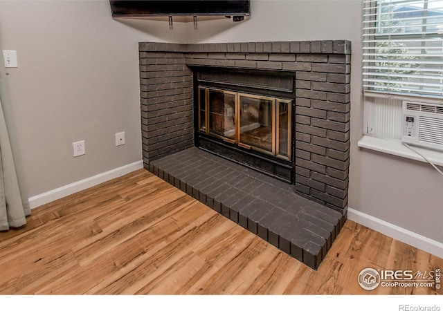 details with hardwood / wood-style flooring, cooling unit, and a fireplace