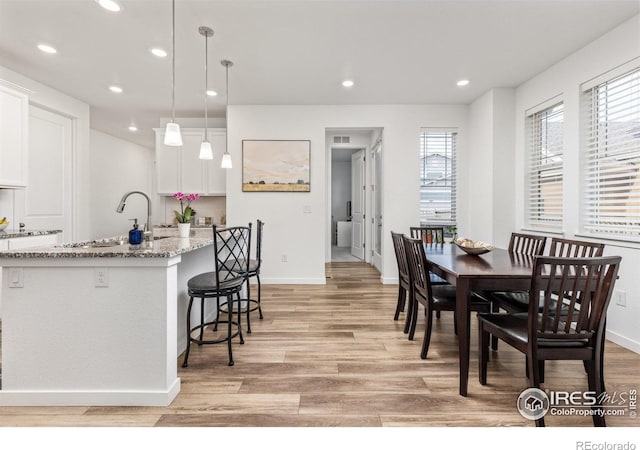 dining space with sink and light hardwood / wood-style flooring