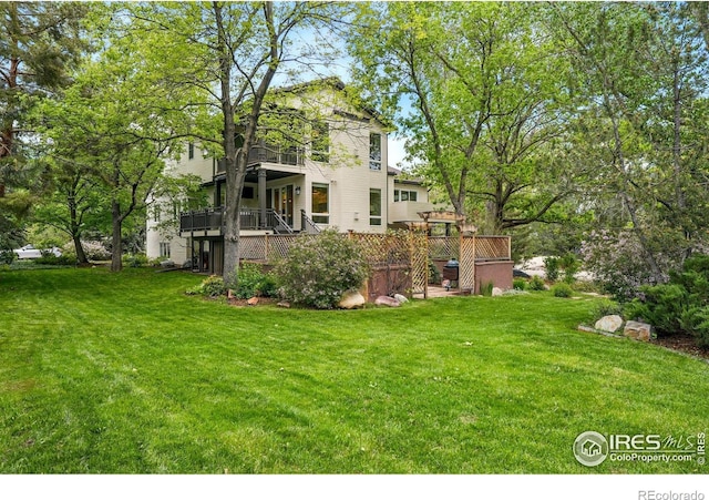 view of green lawn with a balcony, stairs, and a deck
