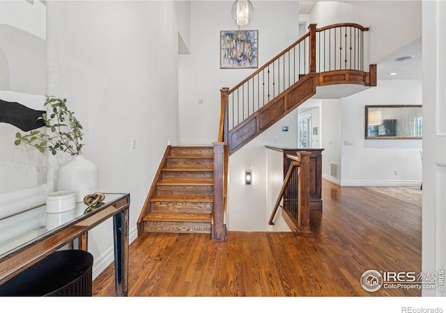 staircase featuring wood finished floors and baseboards