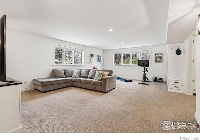 carpeted living area with recessed lighting and baseboards