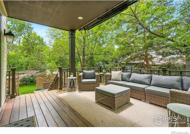 wooden deck featuring an outdoor hangout area and view of wooded area