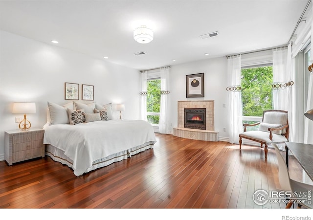 bedroom featuring access to exterior, a fireplace, dark wood-style flooring, recessed lighting, and baseboards