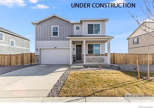 view of front of property with a porch, a garage, and a front yard