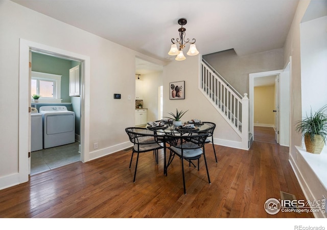 dining area with washing machine and dryer, dark hardwood / wood-style floors, and an inviting chandelier