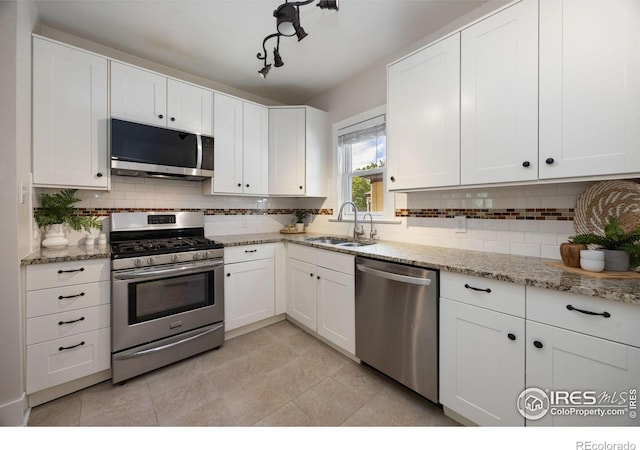 kitchen featuring appliances with stainless steel finishes, sink, and white cabinets