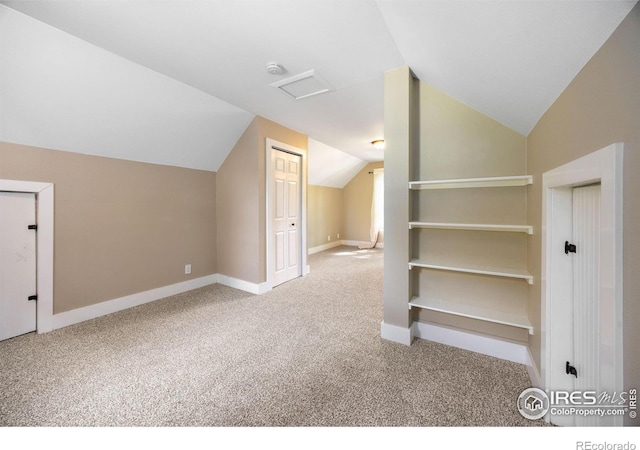 bonus room featuring vaulted ceiling and light colored carpet