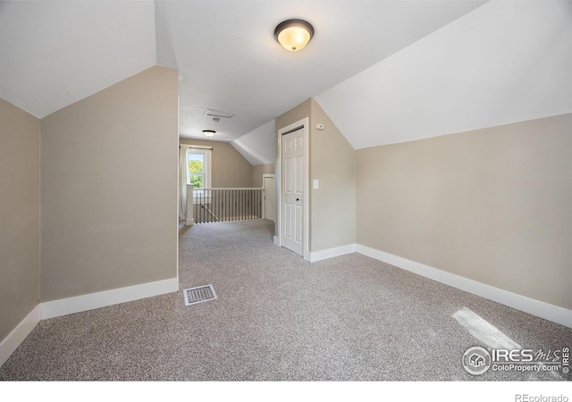 additional living space with carpet floors and vaulted ceiling