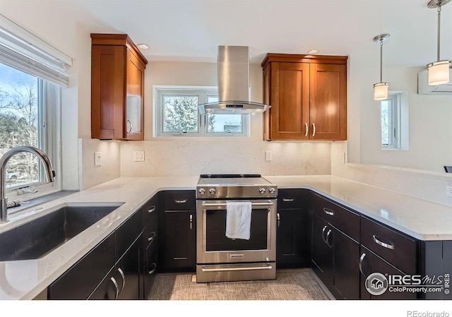 kitchen featuring a sink, brown cabinets, stainless steel range with electric cooktop, and wall chimney range hood