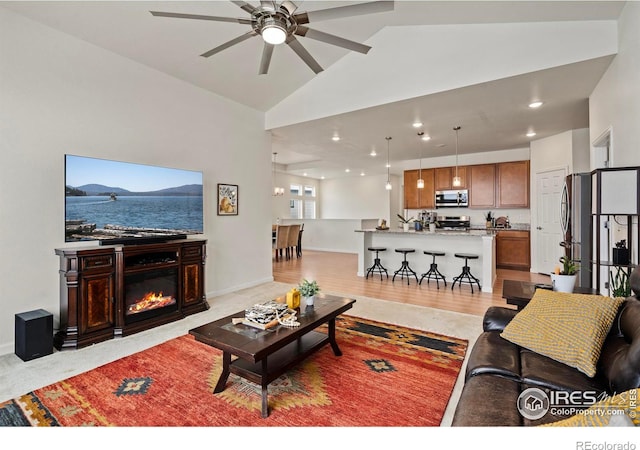 living room with ceiling fan, lofted ceiling, and light hardwood / wood-style floors