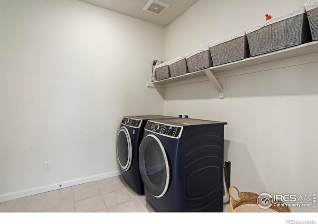 laundry area featuring separate washer and dryer and light tile patterned floors