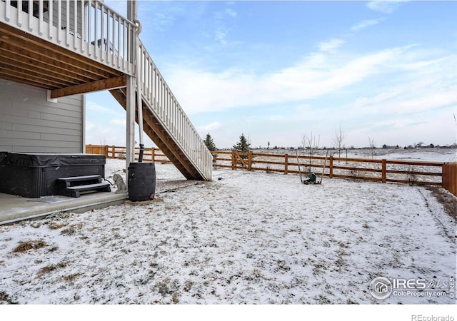 yard covered in snow featuring a hot tub